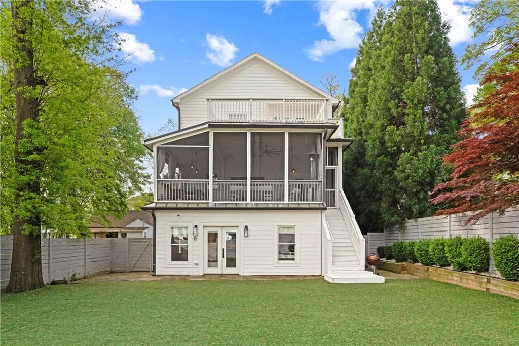 Back of the house has a primary suite balcony, main level screened porch and walk out terrace level.