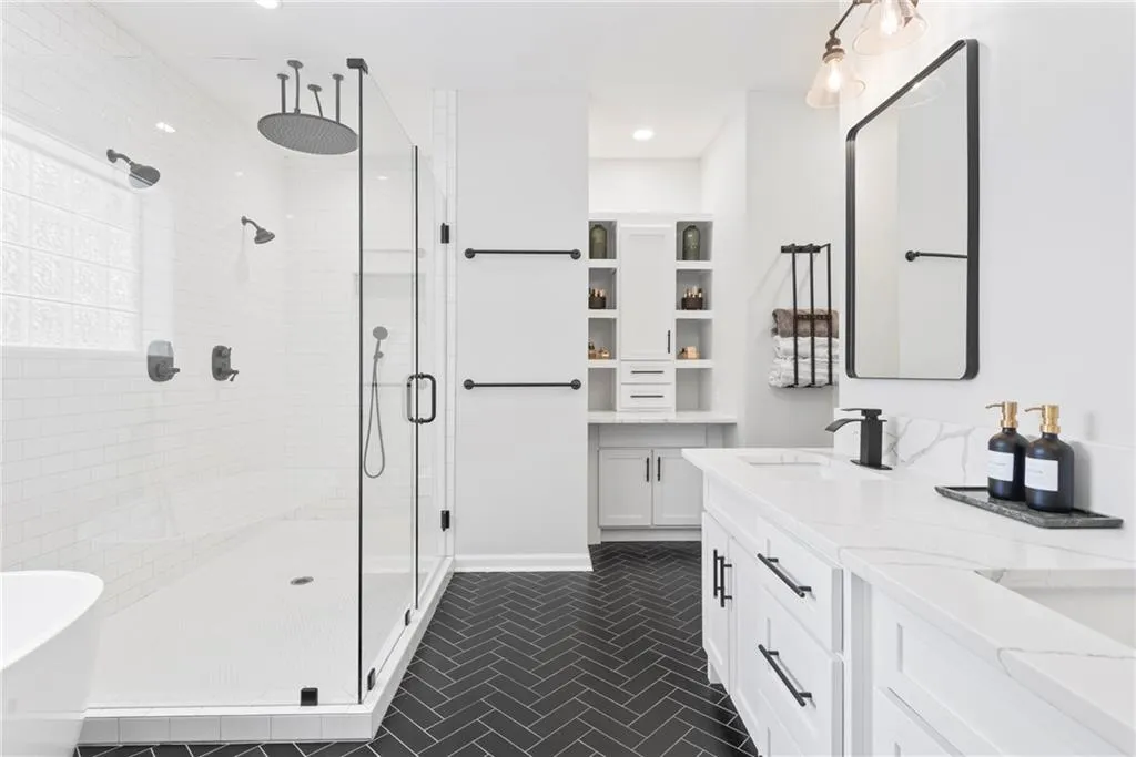 Incredile white bath set upon black herringbone tile floor - such a beautiful contrast