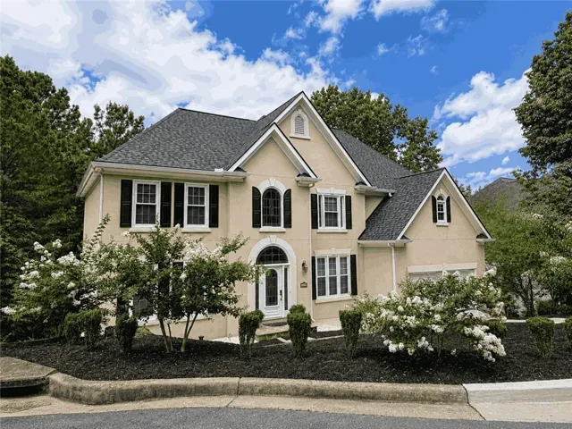 Stucco exterior with multiple gables and a dark shingle roof