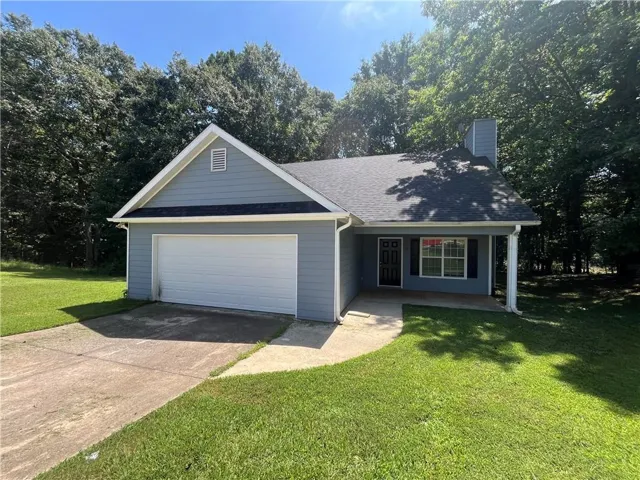Light blue siding exterior with an attached garage, a covered entry, and a dark asphalt shingle roof