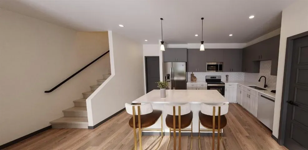 Kitchen with pendant lighting, stainless steel appliances, backsplash, modern cabinets, and a breakfast bar