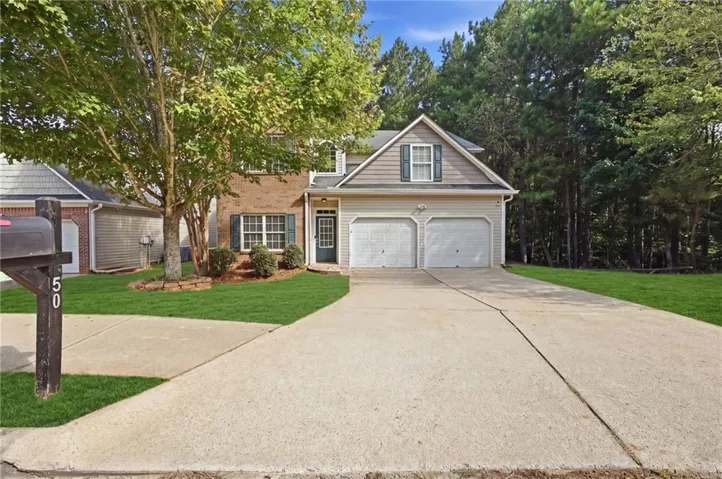 Two-story residence with brick and siding facade, featuring a prominent two-car garage