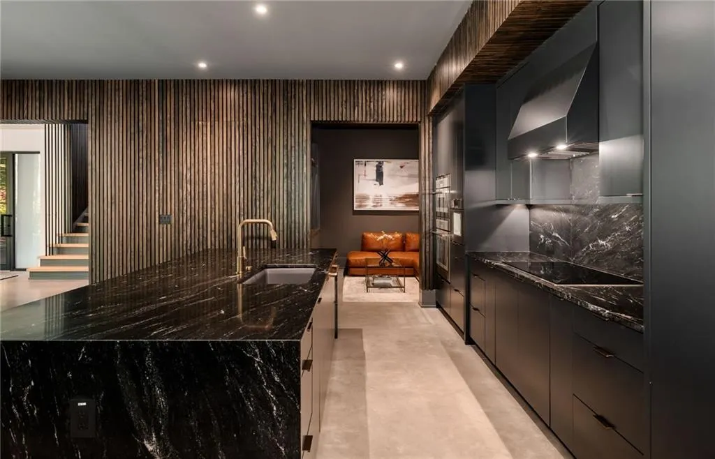Kitchen featuring a center island with sink, dark stone counters, wall chimney range hood, sink, and black electric stovetop