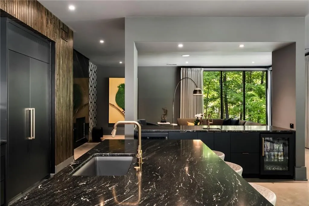 Kitchen with wine cooler, sink, stainless steel built in fridge, and dark stone countertops