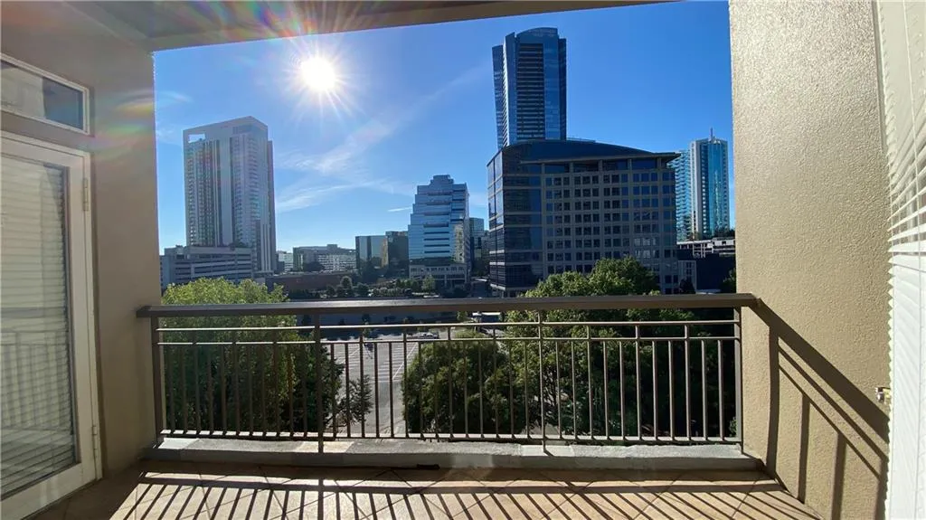 Balcony featuring a metal railing and city skyline backdrop