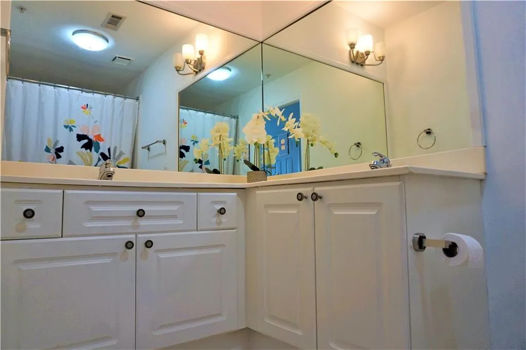 White shaker-style cabinetry with dark hardware and a built-in sink vanity