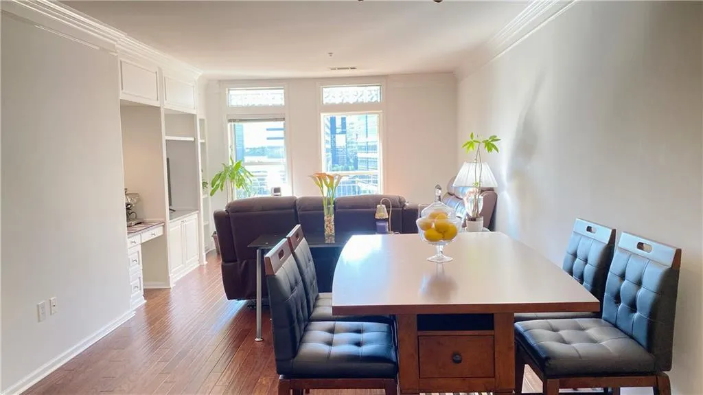 Hardwood flooring, crown molding, built-in cabinetry, built-in desk, and multiple windows