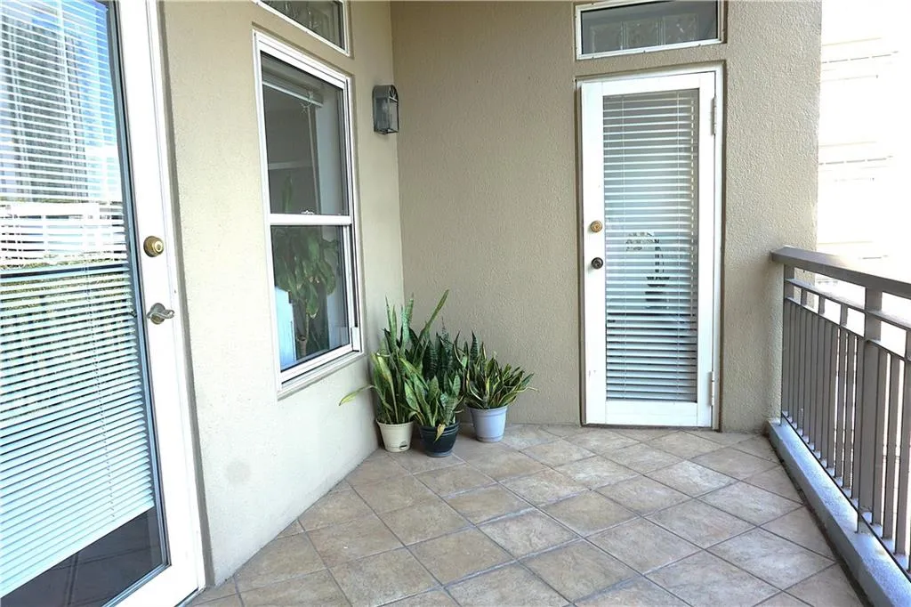 Balcony featuring tile flooring, metal railing, and stucco exterior walls