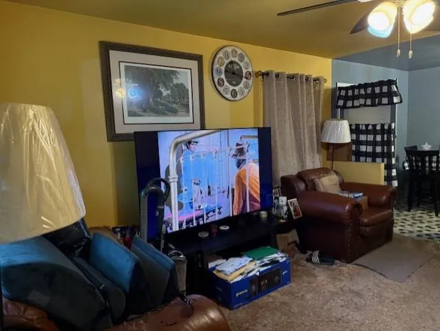 Living area featuring carpet and ceiling fan