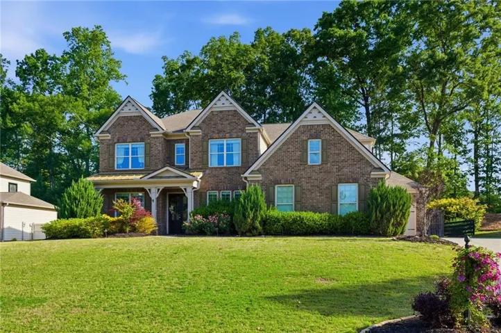 Brick exterior featuring gabled rooflines, decorative shutters, and a covered front entry