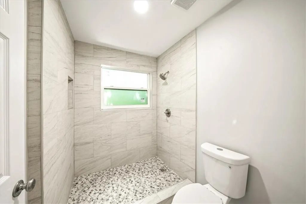 Bathroom featuring toilet and tiled shower