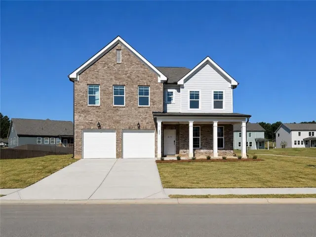 Brick and siding exterior with a covered front porch, a two-car garage, and a concrete driveway