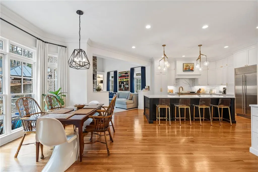 Dining area with ornamental molding and light hardwood / wood-style flooring