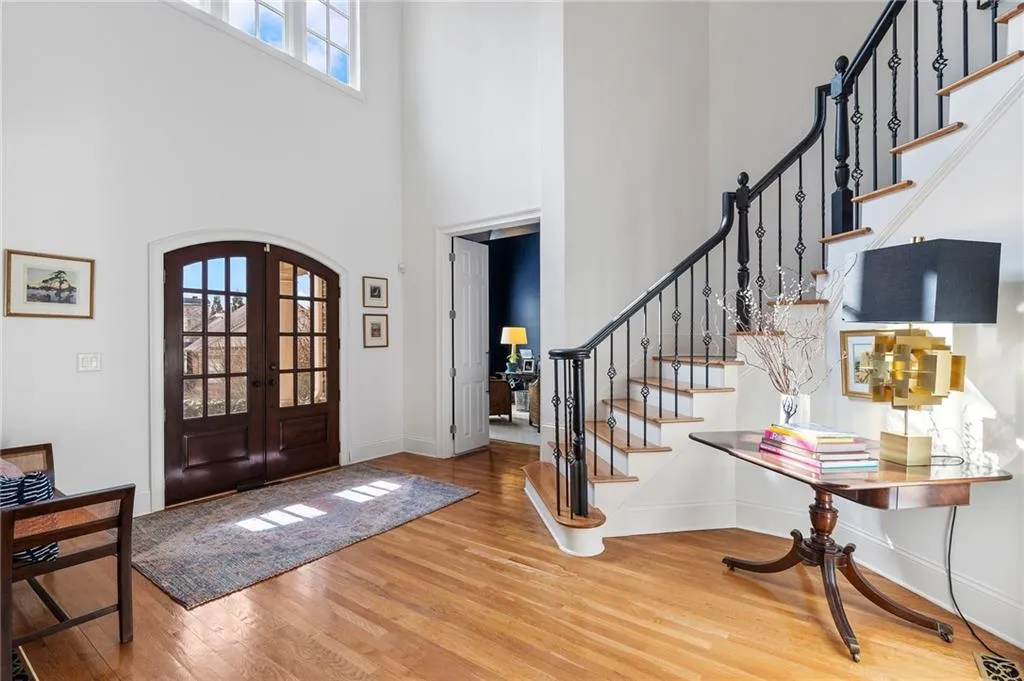 Entrance foyer with french doors, a towering ceiling, and hardwood / wood-style flooring