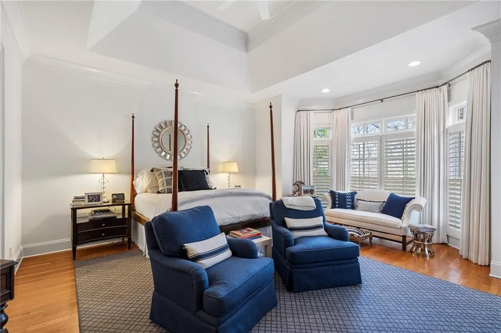 Bedroom with hardwood / wood-style flooring, ornamental molding, and a raised ceiling