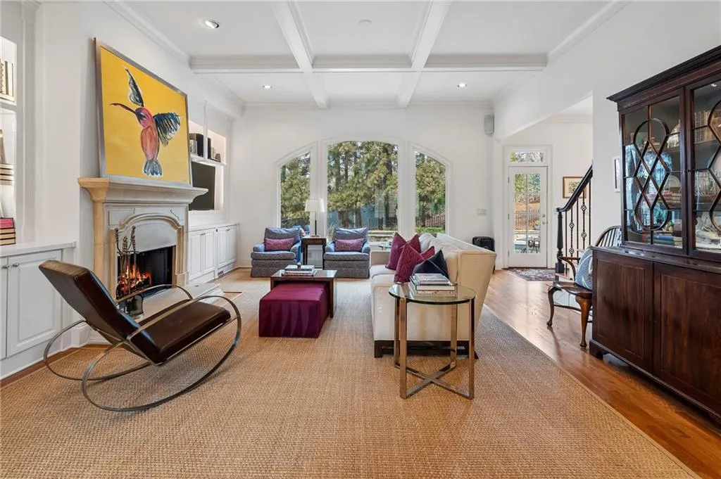 Living room featuring crown molding, coffered ceiling, beam ceiling, and light hardwood / wood-style flooring
