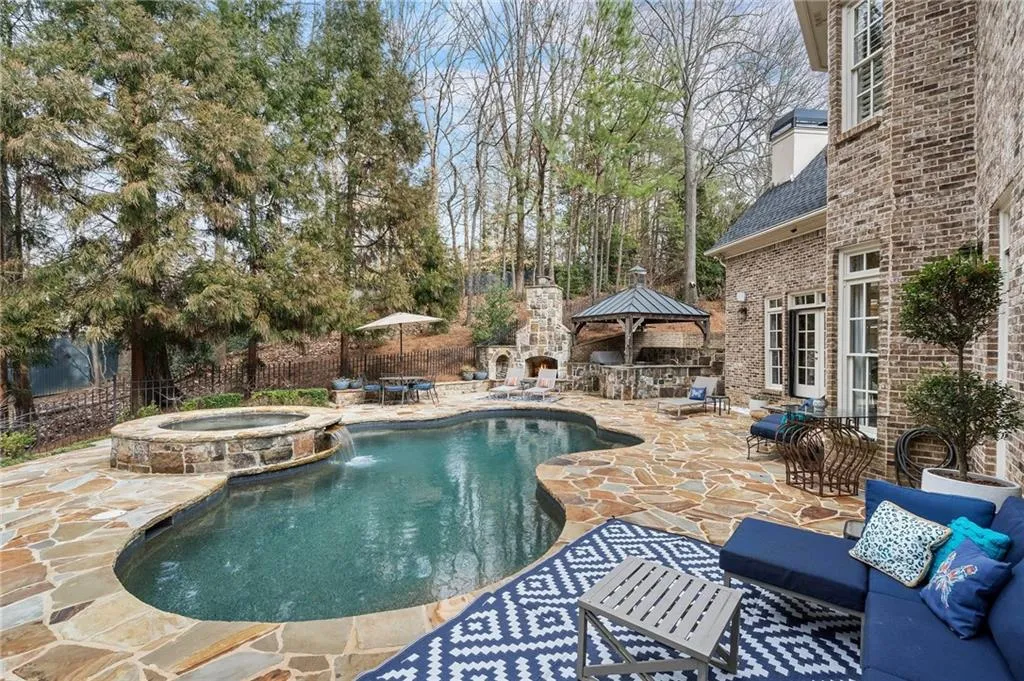 View of swimming pool with pool water feature, a patio, an outdoor living space with a fireplace, and an in ground hot tub