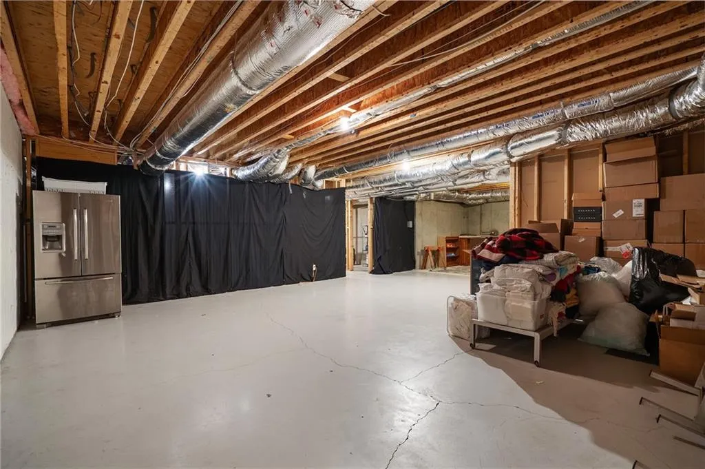 Basement with stainless steel fridge with ice dispenser