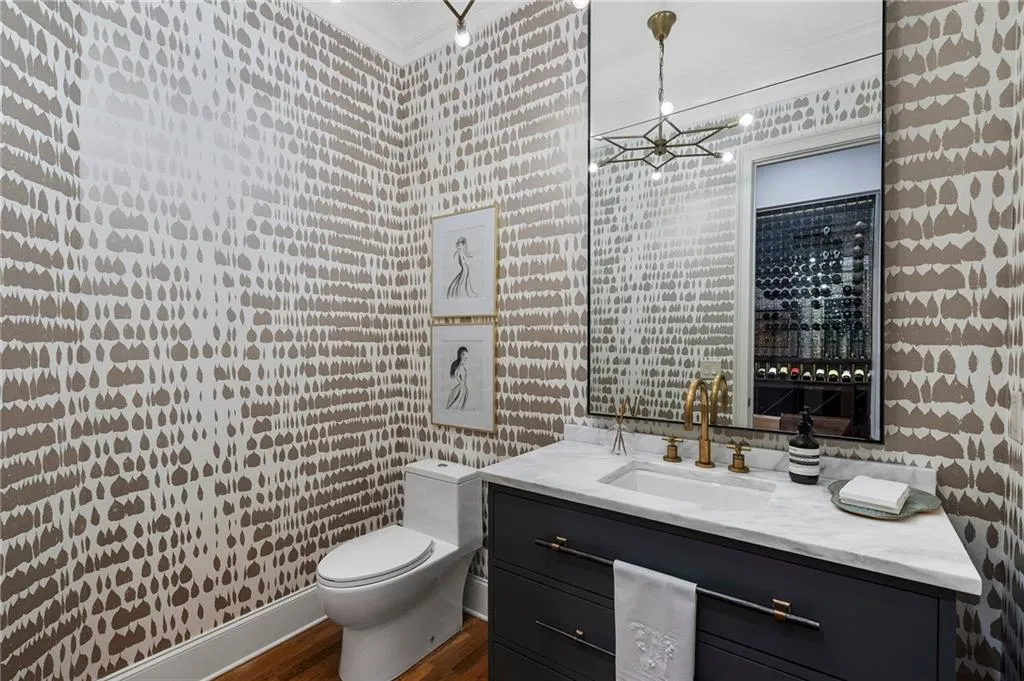 Bathroom featuring an inviting chandelier, vanity, toilet, and hardwood / wood-style floors