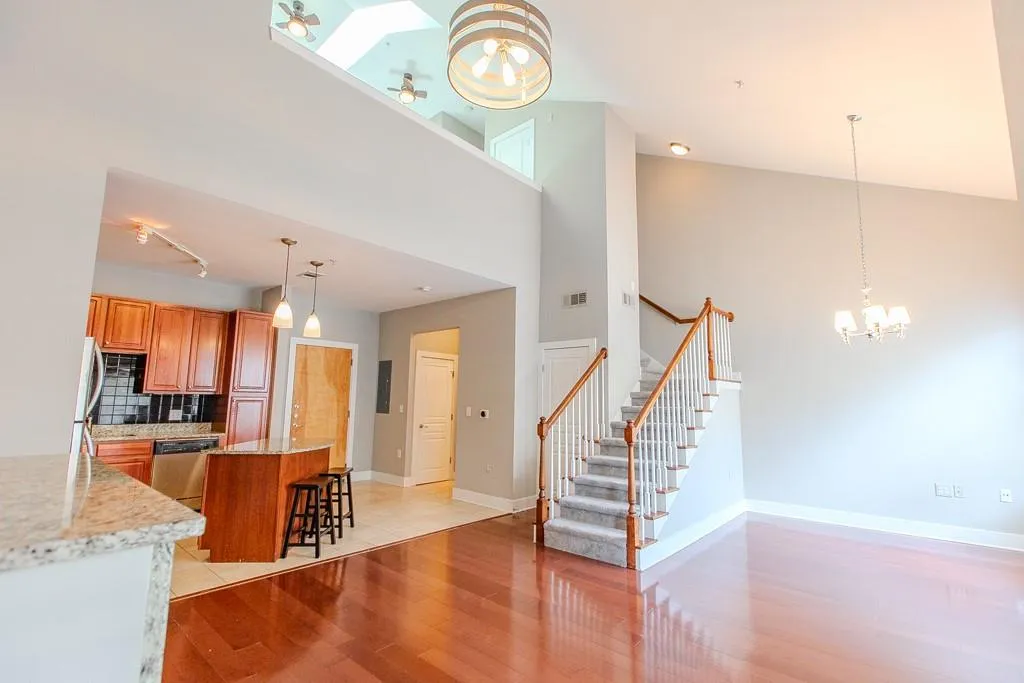 Kitchen with light stone countertops, tasteful backsplash, stainless steel appliances, light wood-type flooring, and a breakfast bar area Kitchen with light stone countertops, tasteful backsplash, stainless steel appliances, light wood-type flooring, and a breakfast bar area