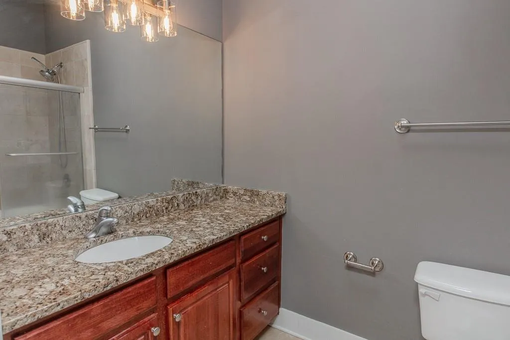 Bathroom with an enclosed shower, vanity, and toilet Bathroom with an enclosed shower, vanity, and toilet