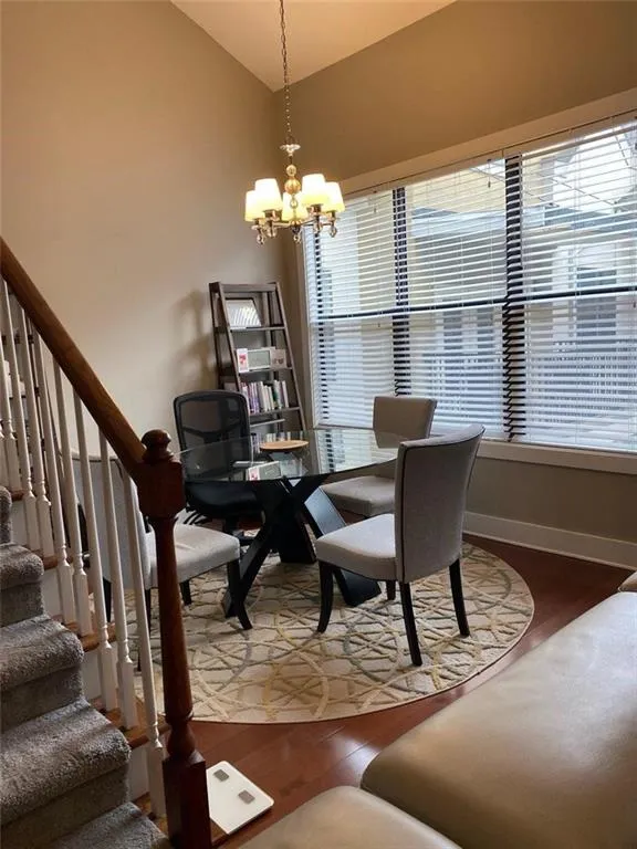 Dining room featuring a chandelier, hardwood / wood-style flooring, and a wealth of natural light Dining room featuring a chandelier, hardwood / wood-style flooring, and a wealth of natural light