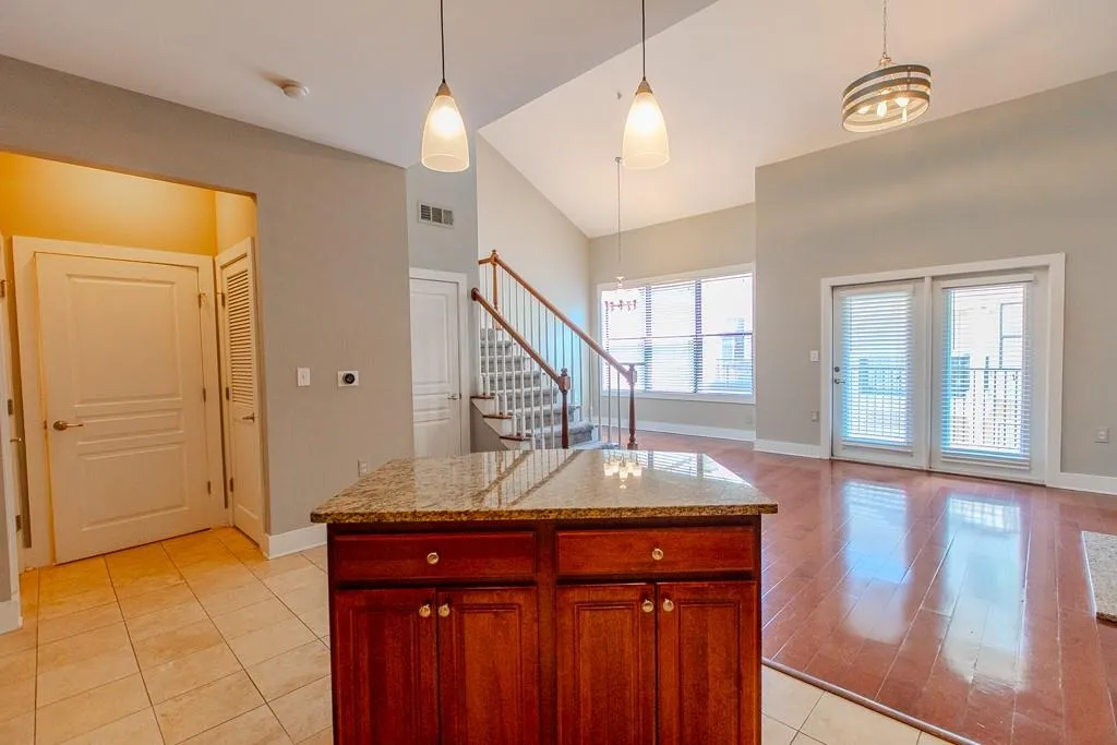 Kitchen featuring a healthy amount of sunlight, hanging light fixtures, and light hardwood / wood-style floors Kitchen featuring a healthy amount of sunlight, hanging light fixtures, and light hardwood / wood-style floors