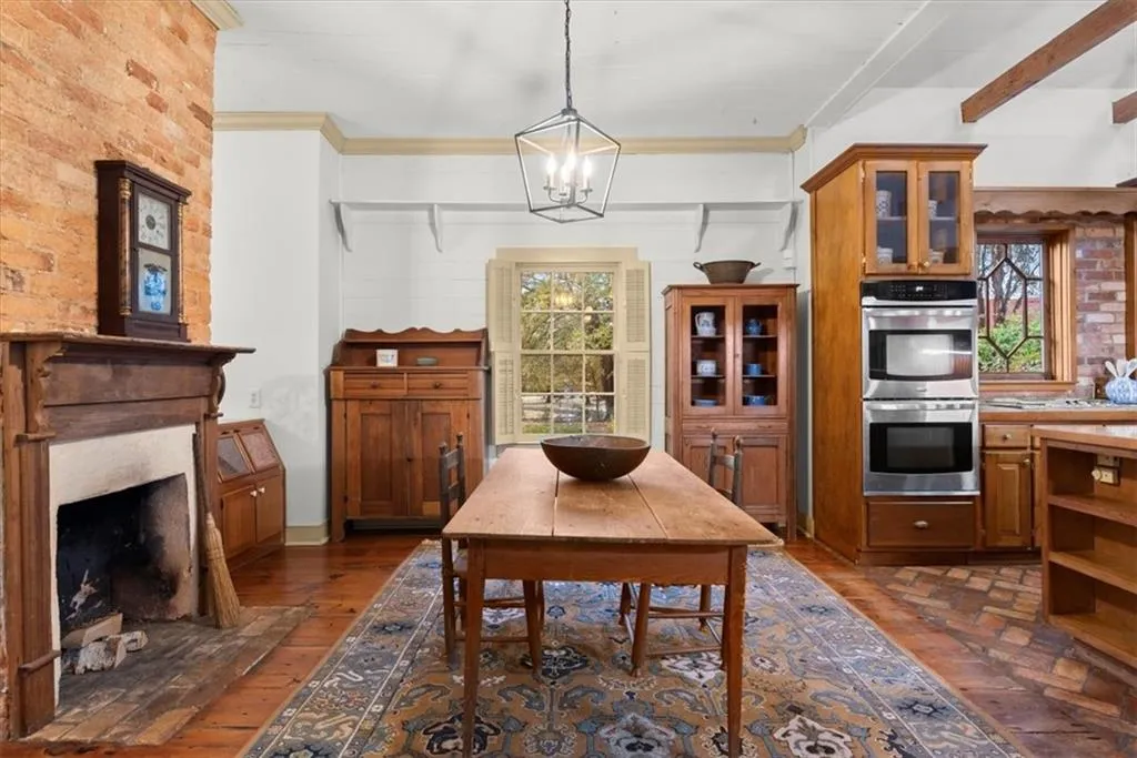 Eat in kitchen with fireplace, original wood floors and handblown era windows