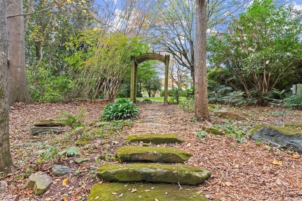 An arbor leads to the woodland garden