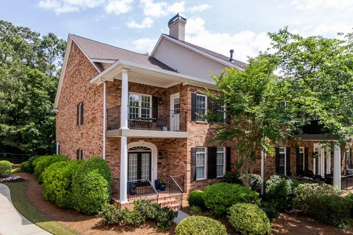 Brick exterior featuring a gabled roofline and dark functional shutters