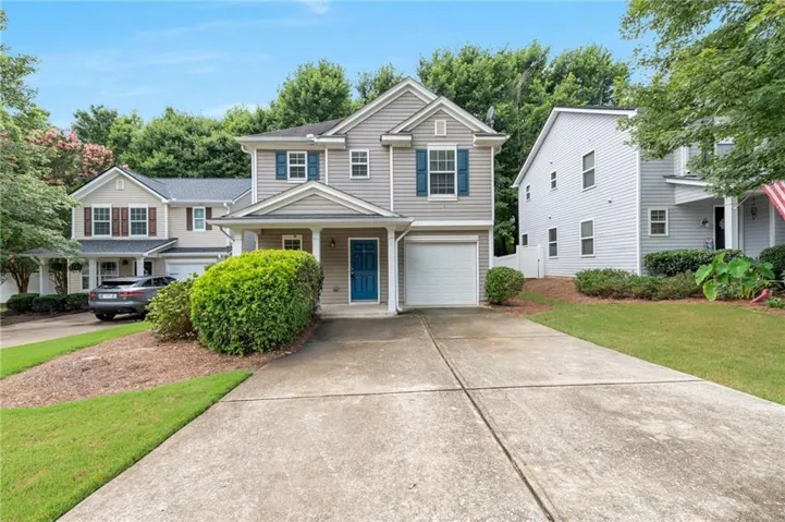 Two-story residence featuring light gray siding with blue window shutters and a blue entry door