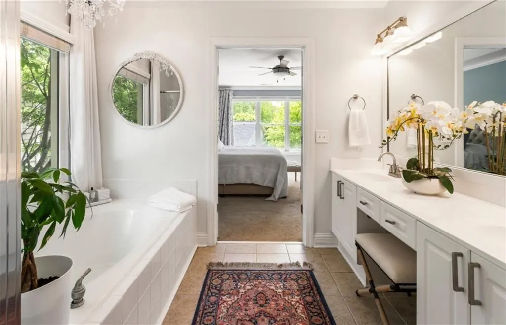 Full bath with ensuite bathroom, a sink, tile patterned floors, and a healthy amount of sunlight