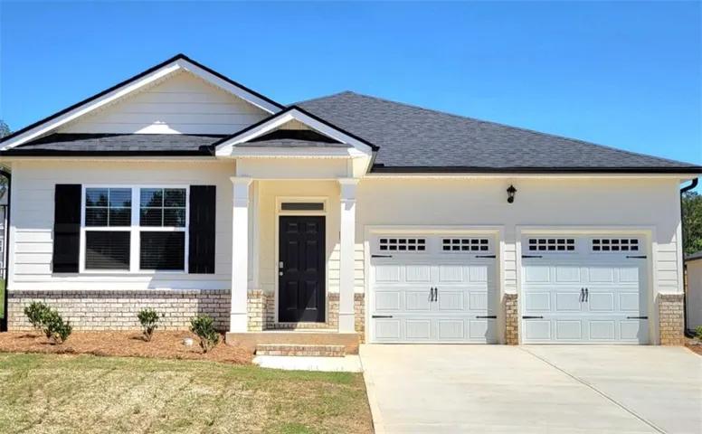 Modern single-story residence featuring a cream and white exterior with architectural detail