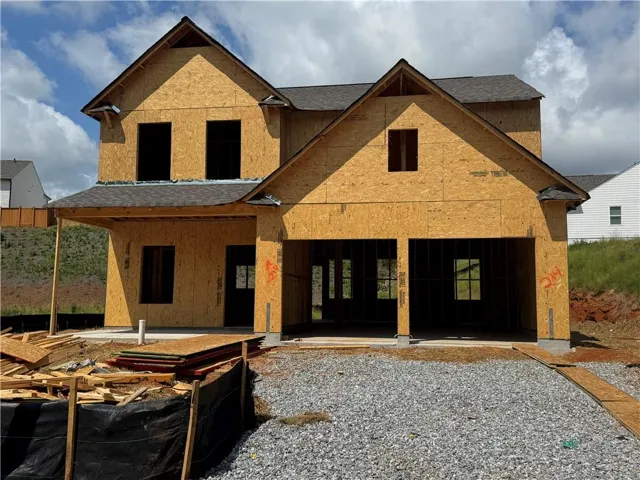 New construction residence featuring a two-story design, attached two-car garage, covered porch entry, multiple gables, and a dark shingle roof