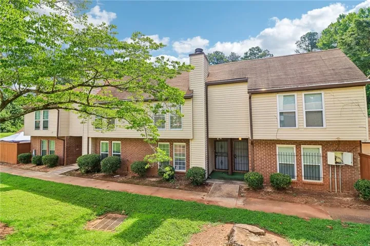 Multi-level townhome exterior featuring brick and vinyl siding
