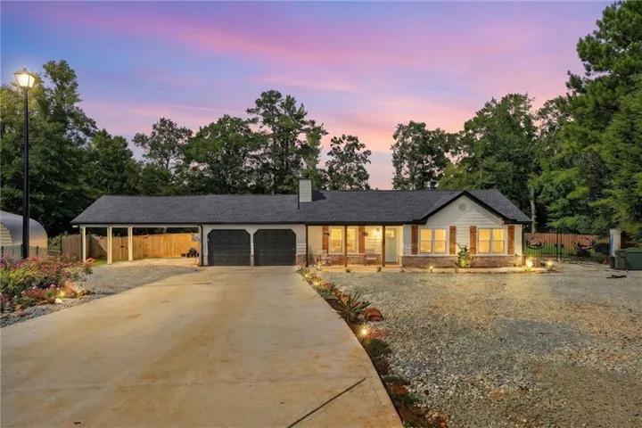 Ranch-style exterior with white siding and brick accents