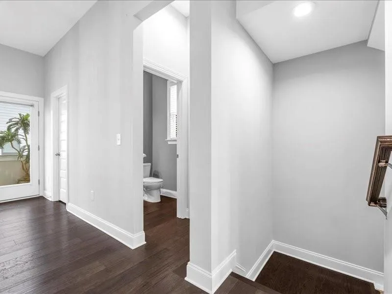 Hall with dark wood-style floors and baseboards