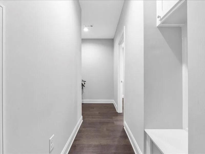 Hall featuring dark wood-style flooring and recessed lighting