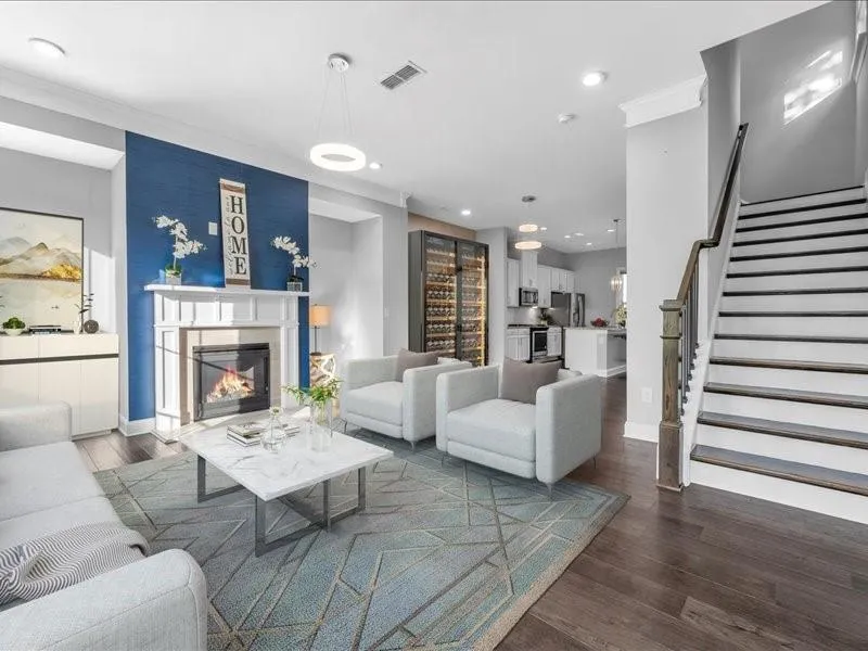 Living area featuring dark wood-style floors, stairway, recessed lighting, a glass covered fireplace, and ornamental molding