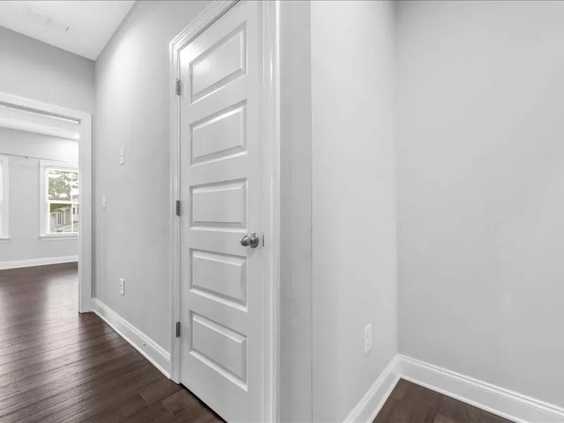 Hall featuring dark wood finished floors and baseboards