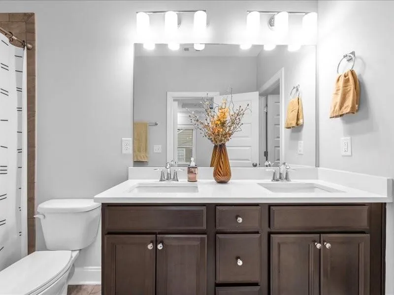 Full bathroom with double vanity and a shower with curtain