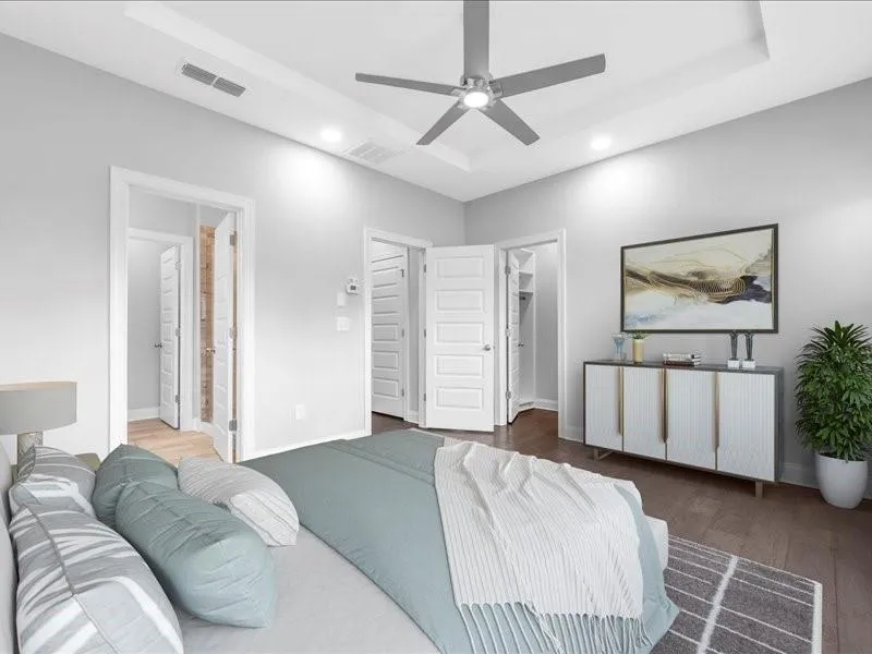 Bedroom with a raised ceiling, recessed lighting, wood finished floors, and ceiling fan