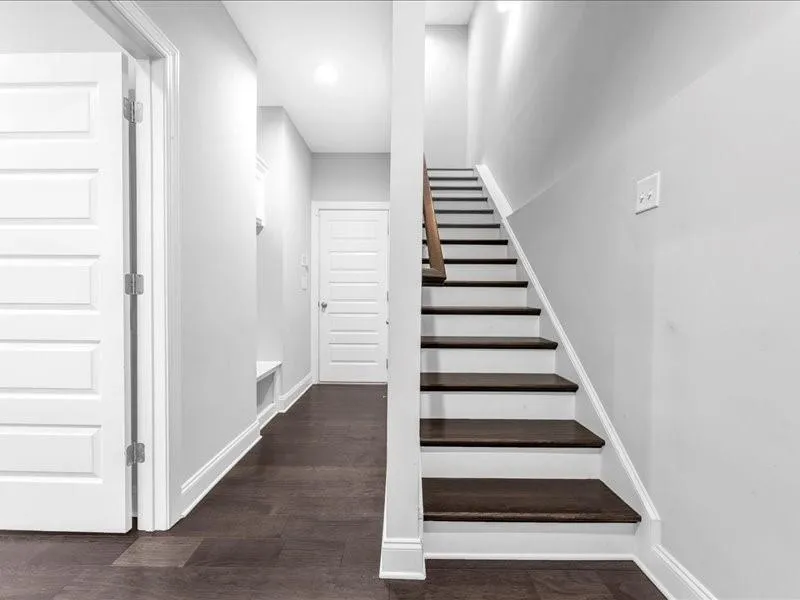 Staircase featuring wood finished floors and recessed lighting