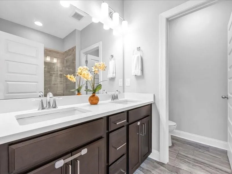 Bathroom featuring double vanity and tiled shower