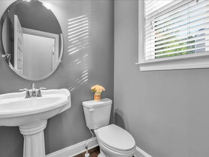 Half bath featuring baseboards and wood finished floors