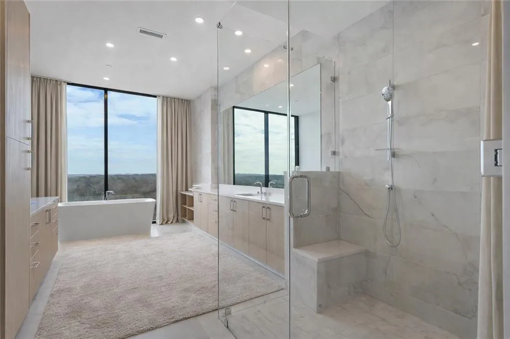 Primary spa like bath with soaking tub overlooking western tree canopy views, dual vanities, spacious shower with dual shower heads and Groehe fixtures and Toto toilets.