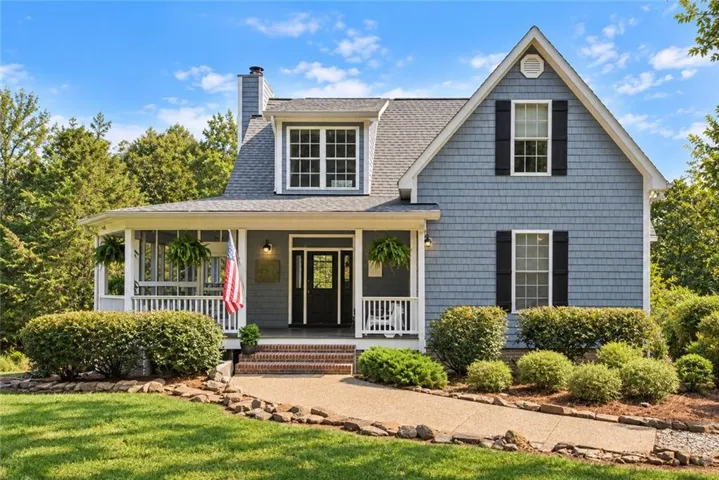 Expansive front yard with a concrete pathway leading to a screened-in porch and front entry