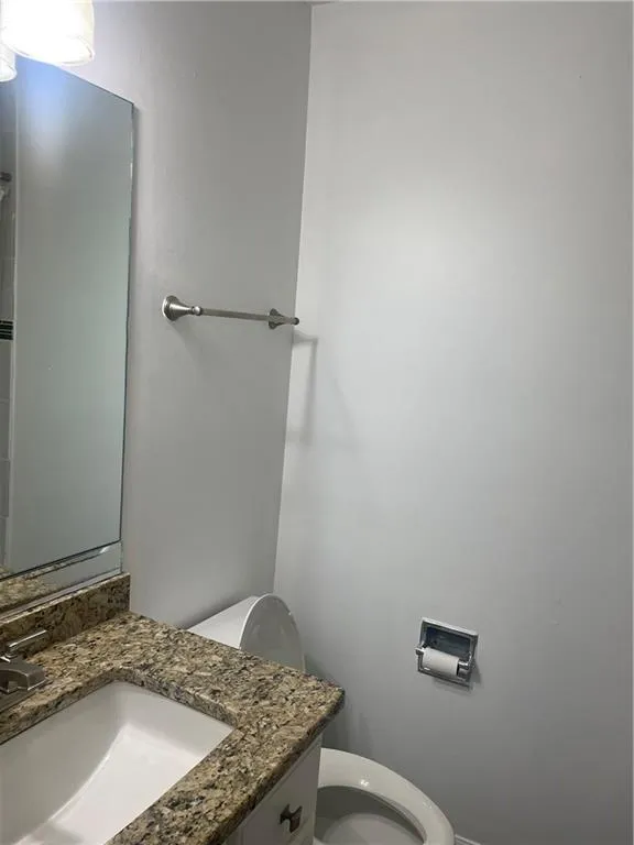 Half bathroom featuring vanity and toilet