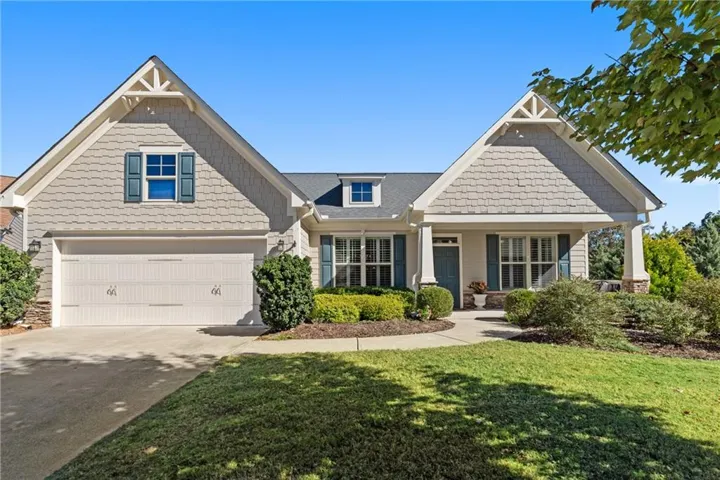 Craftsman inspired home featuring concrete driveway, a porch, a front lawn, and stone siding