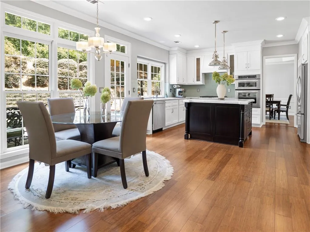 Dining room with sink, crown molding, hardwood / wood-style floors, and a chandelier
